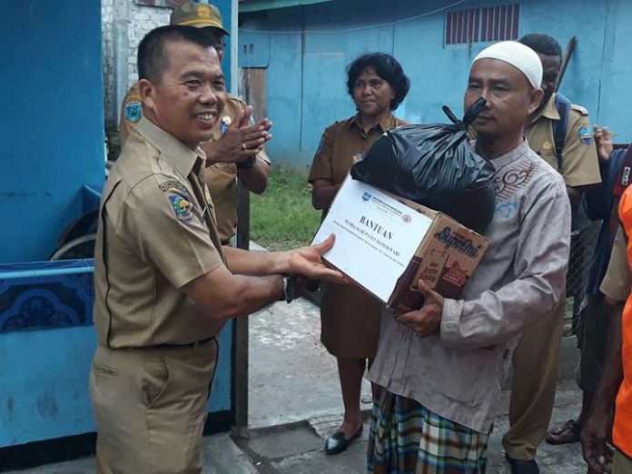 Ketua RT 04/RW 06 Kampung Maduraja, Kelurahan Wosi, Daryanto (kiri) saat menerima paket bantuan yang diserahkan Wanto, Asisten I Pemerintah Kabupaten Manokwari.