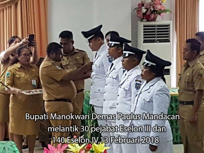 Bupati Manokwari Demas Paulus Mandacan memasang pin tanda jabatan secara simbolis dalam pelantikan 170 pejabat eselon III dan IV, 13 Februari 2018.