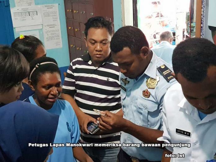 Petugas Lapas Manokwari memeriksa barang bawaan pengunjung.